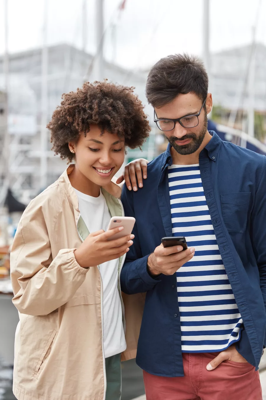 Casal sorrindo olhando o celular — família feliz e protegida com o Supreme Vidas